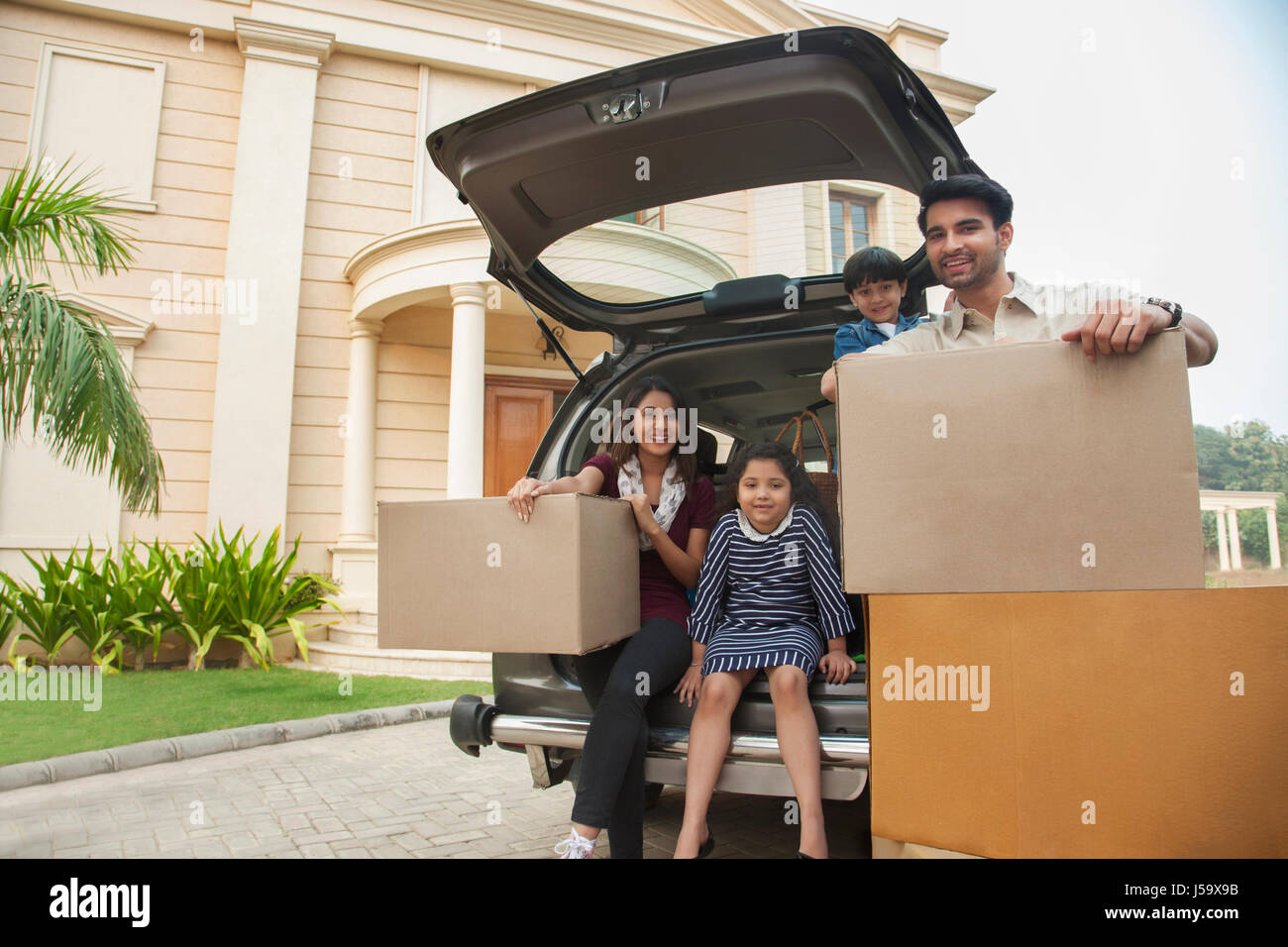 Family unpacking cardboard boxes from car Stock Photo