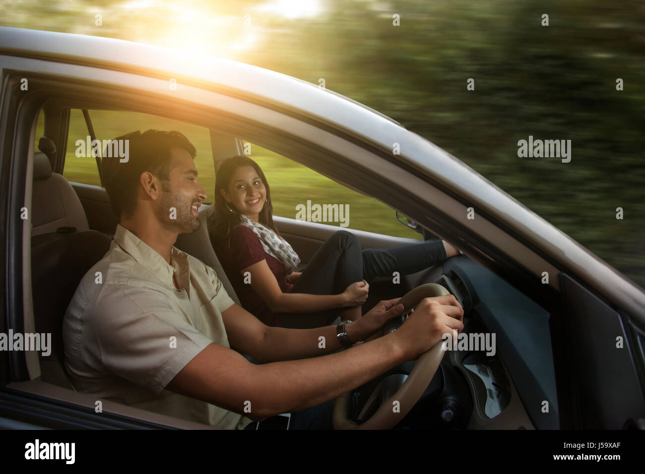 Happy young couple driving in car Stock Photo