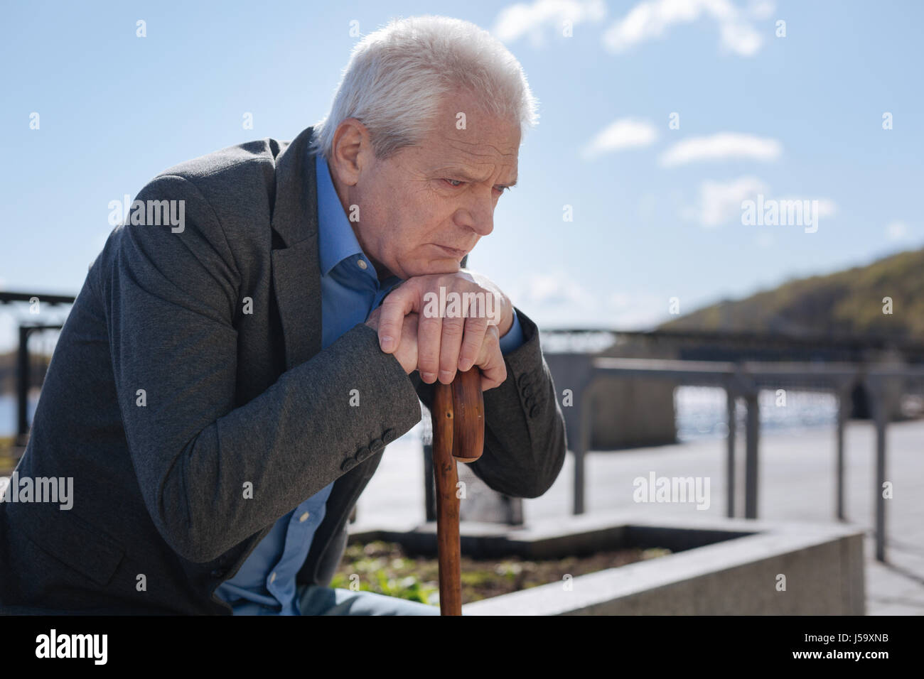 Upset pensioner expressing sadness in the park Stock Photo