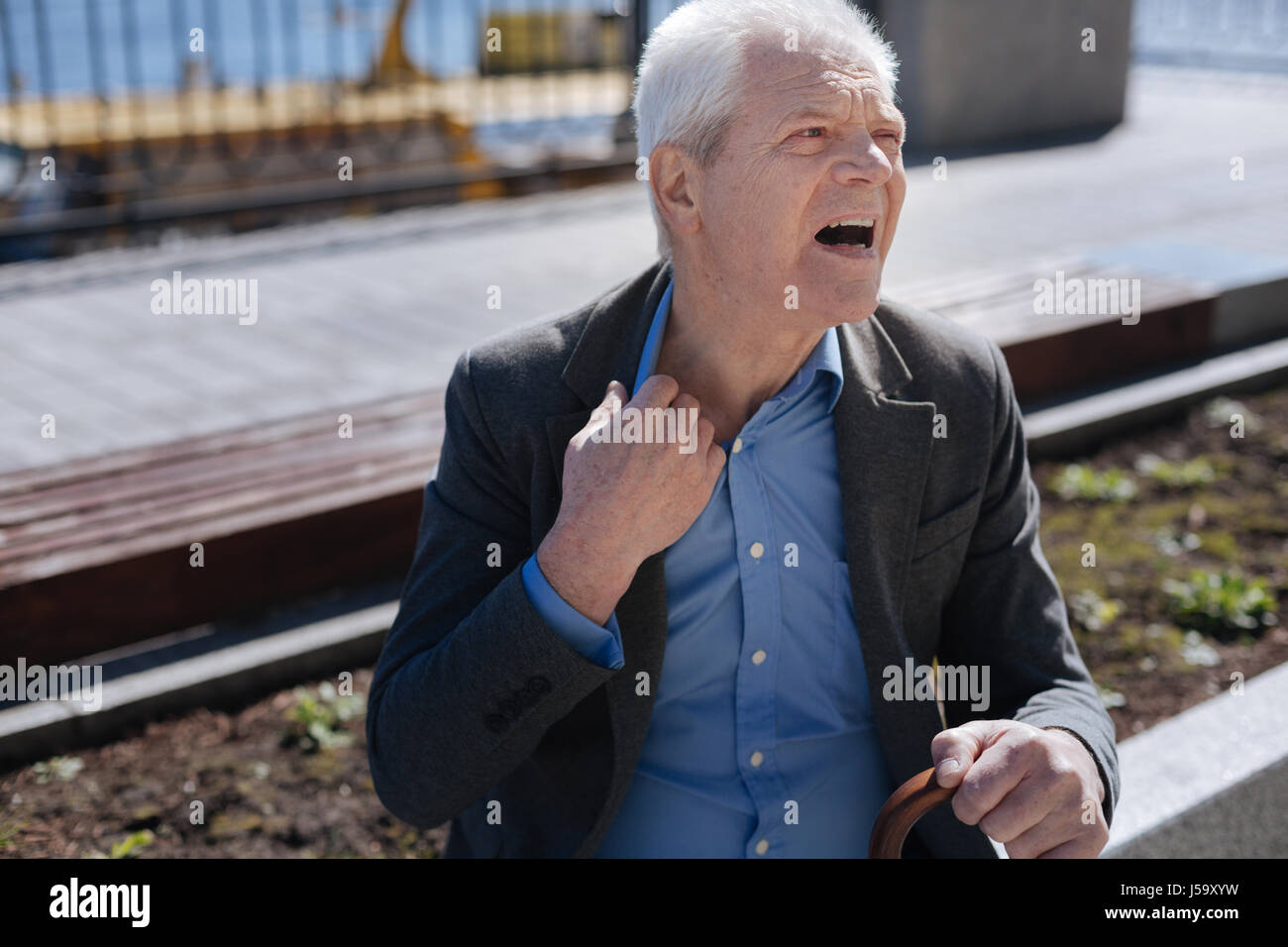 Aging man taking a deep breath on the street Stock Photo