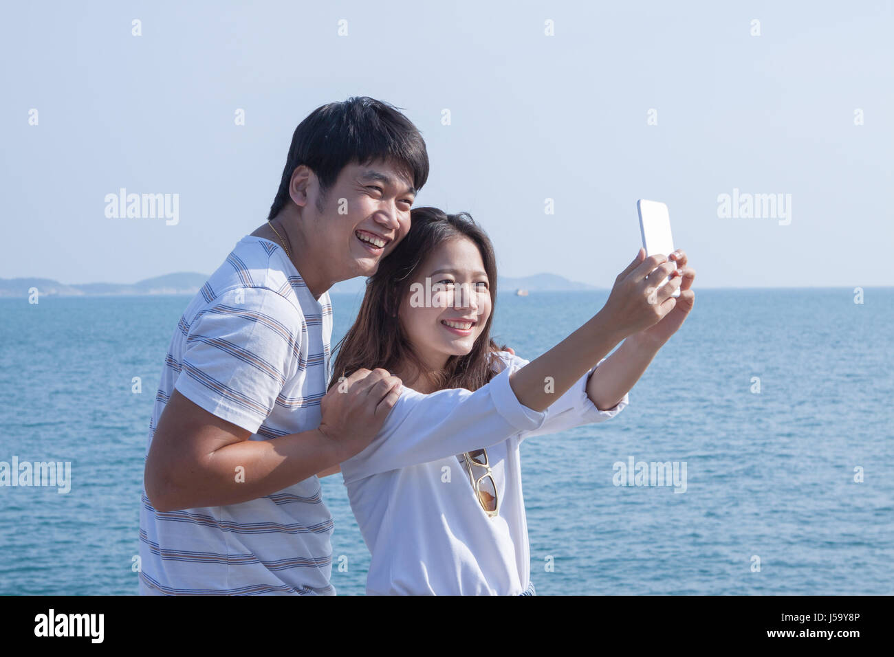portrait of young man and woman selfie ,self portrait by mobile phone in relaxing emotion sea beach destination use for people in modern life style Stock Photo
