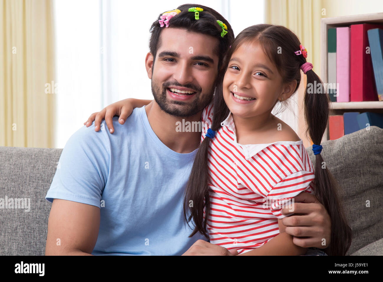 Portrait of funny father wearing hair clips with daughter Stock Photo