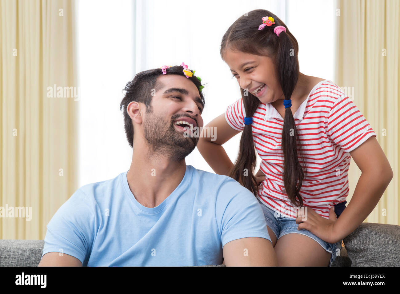 Smiling funny father wearing hair clips like daughter Stock Photo