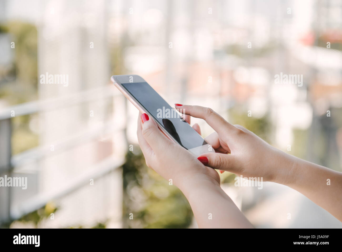 Closeup of woman touching screen of her smartphone Stock Photo