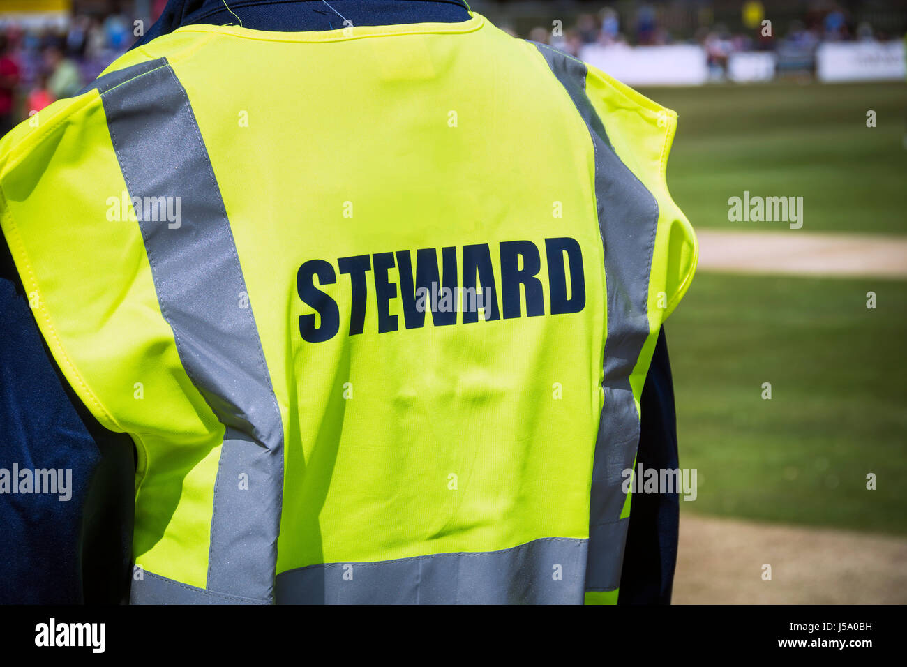 Sports steward by pitch in high viz jacket Stock Photo