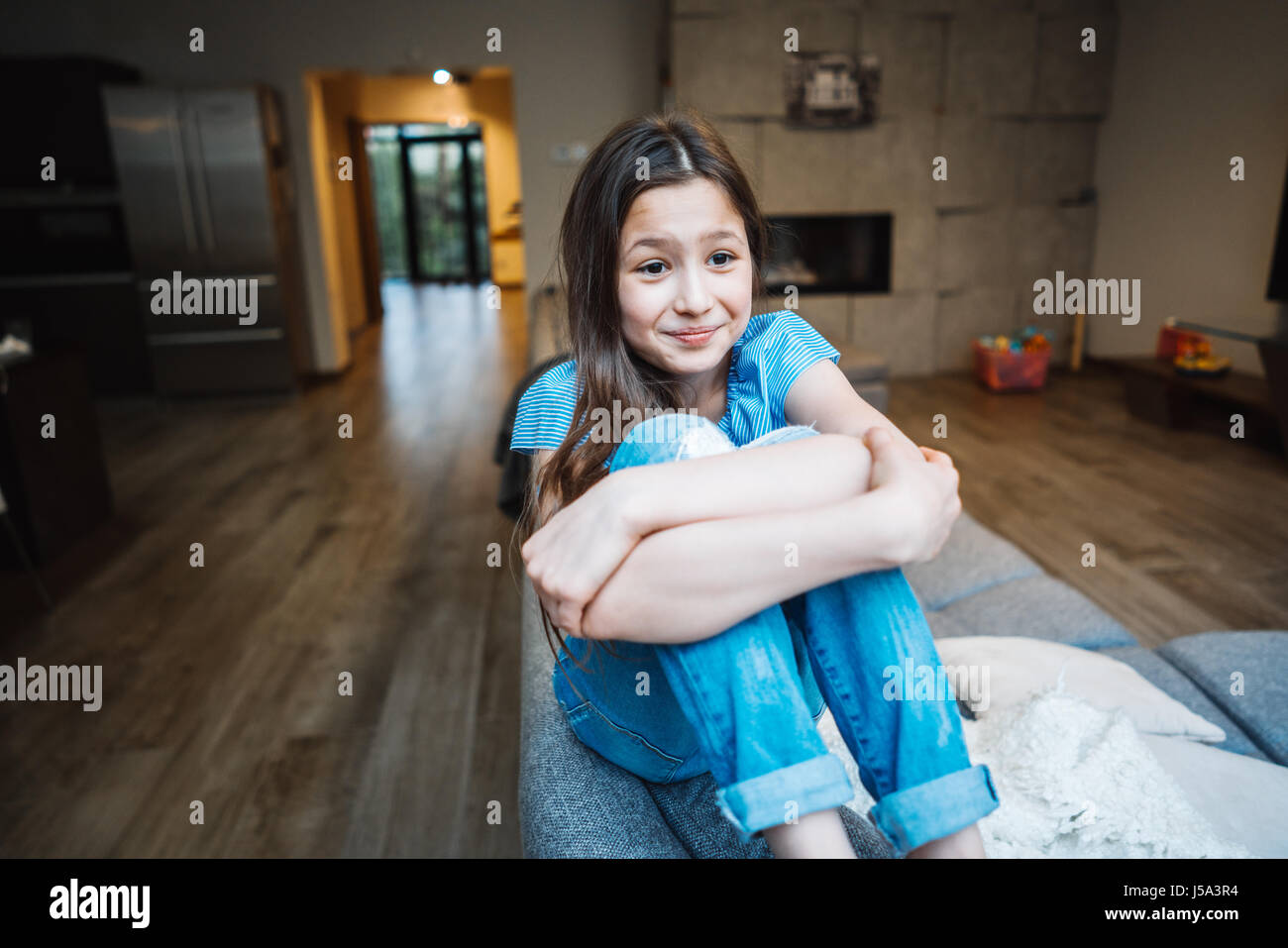 Positive smiling teenage girl on a couch Stock Photo - Alamy