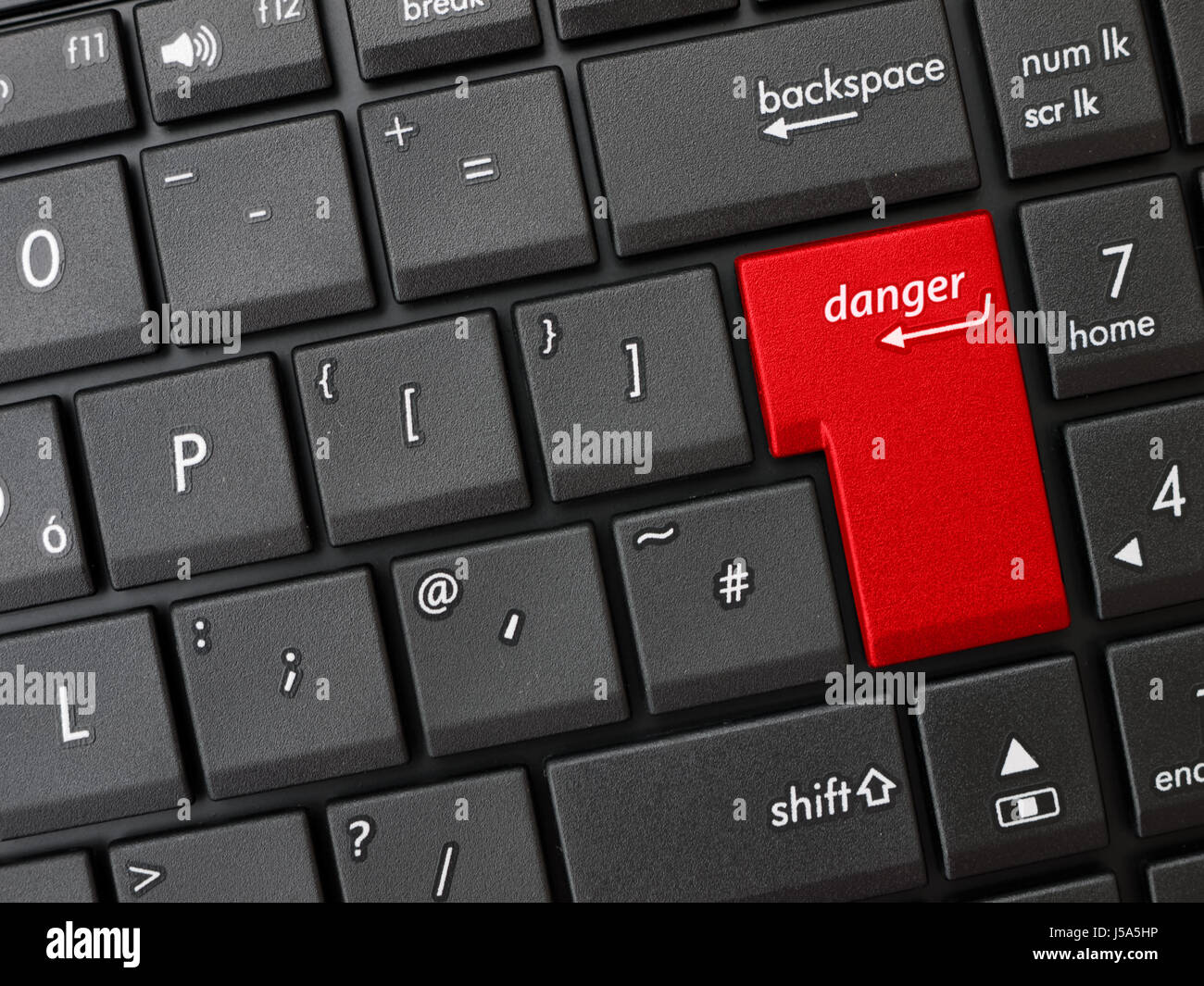 Closeup of keyboard with enter key and danger sign. Stock Photo