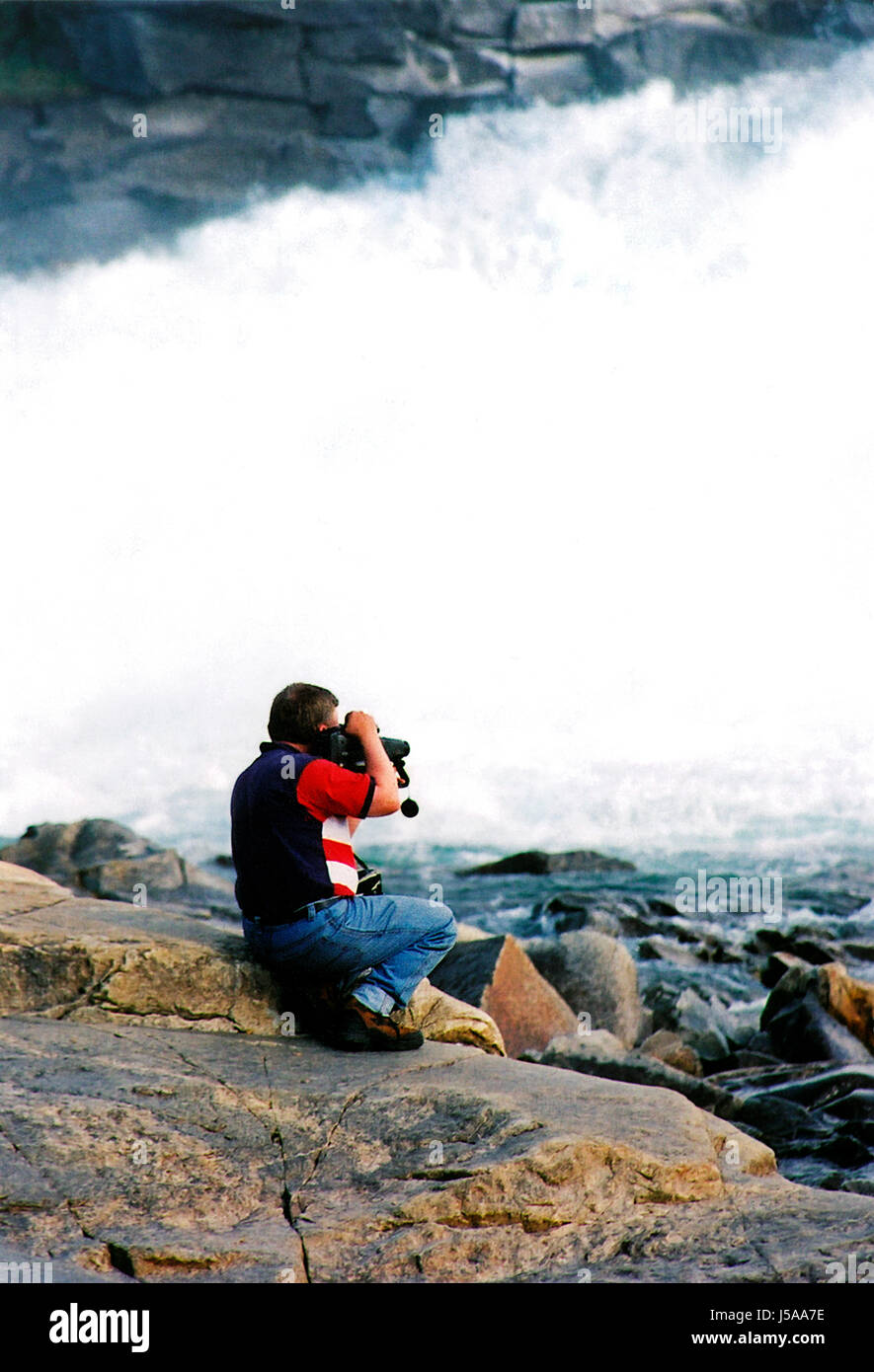 mountains stone human human being waterfall norway genuflecting film movie Stock Photo