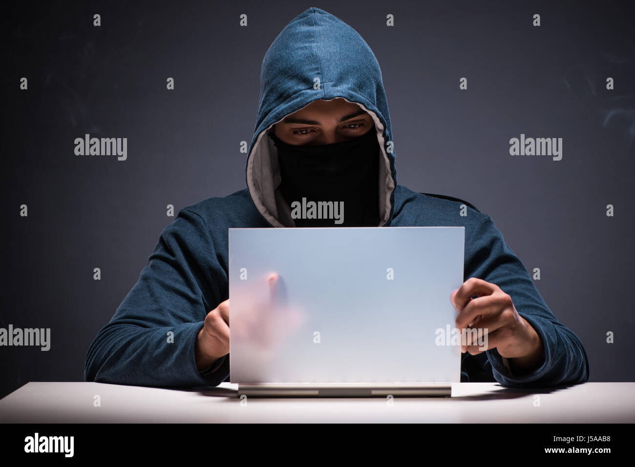 Computer hacker working in dark room Stock Photo - Alamy