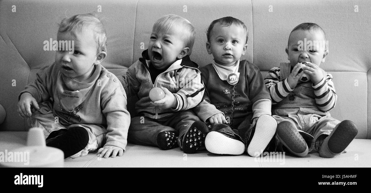 abreast with each other sofa youngsters guys boys infants weep cry crying Stock Photo