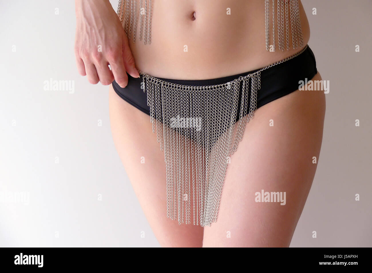 woman hand female skin jewelry jewellery bikini belly tummy bellybutton chains Stock Photo