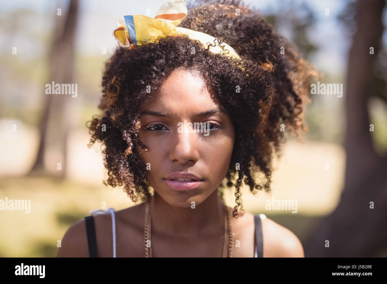 Portrait of young woman standing in forest Stock Photo - Alamy