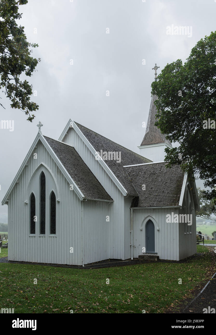 Bay of Islands, New Zealand - March 7, 2017: Historic first settlement mission church called Te Waimate. White church, gray roof, green trees and gras Stock Photo