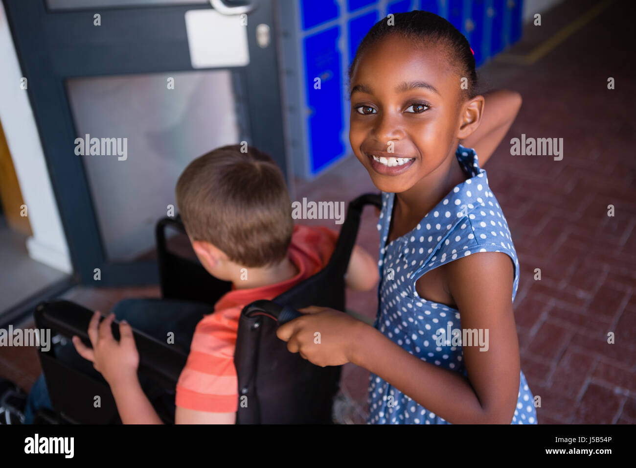 Portrait of smiling girl with classmate in corridor at school Stock ...