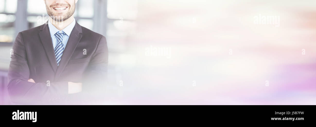 Portrait of happy businessman with arms crossed standing in office ...