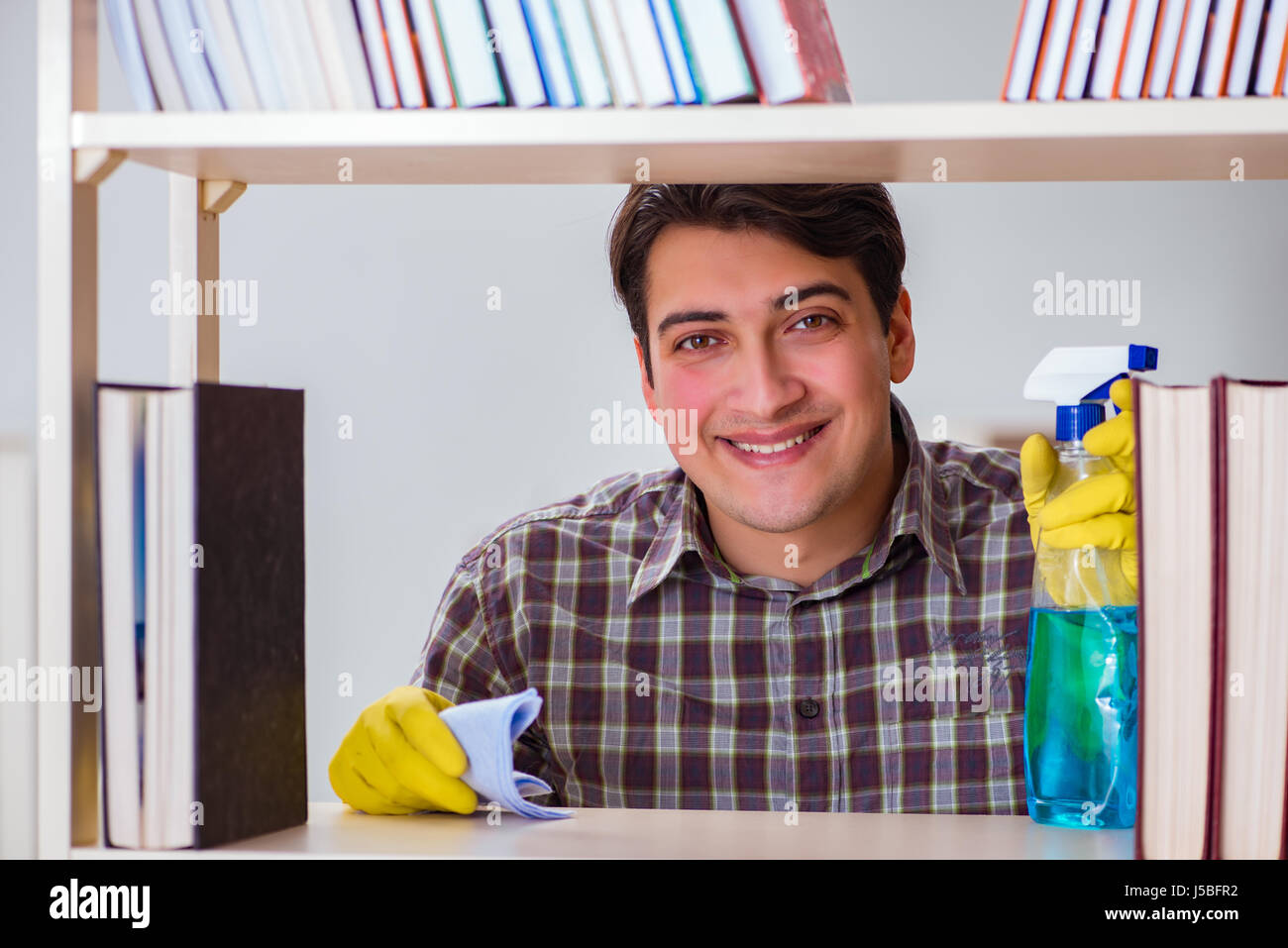 Man cleaning dust from bookshelf Stock Photo Alamy