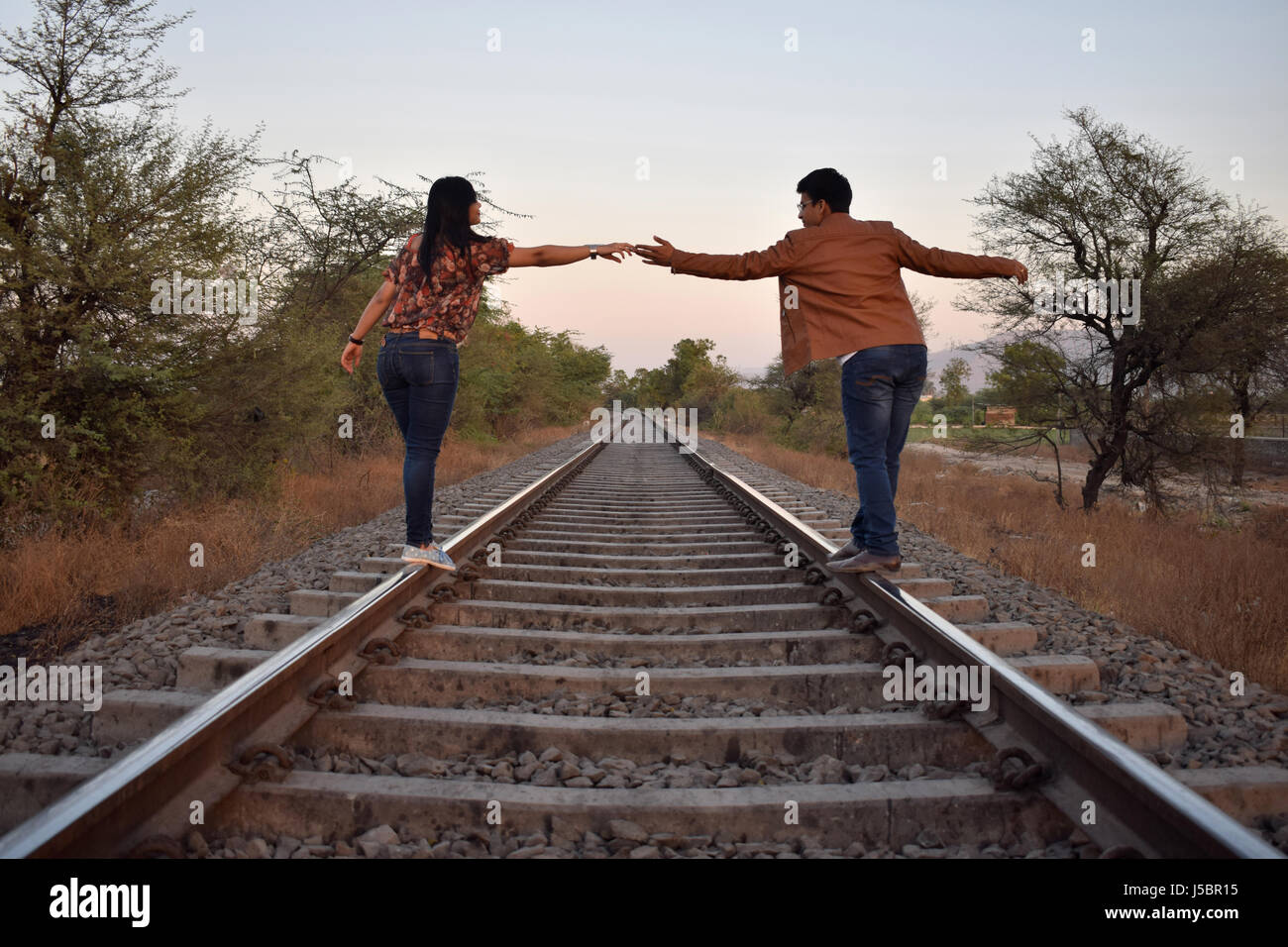 Young couple poses on railroad tracks, Pune, Maharashtra Stock Photo