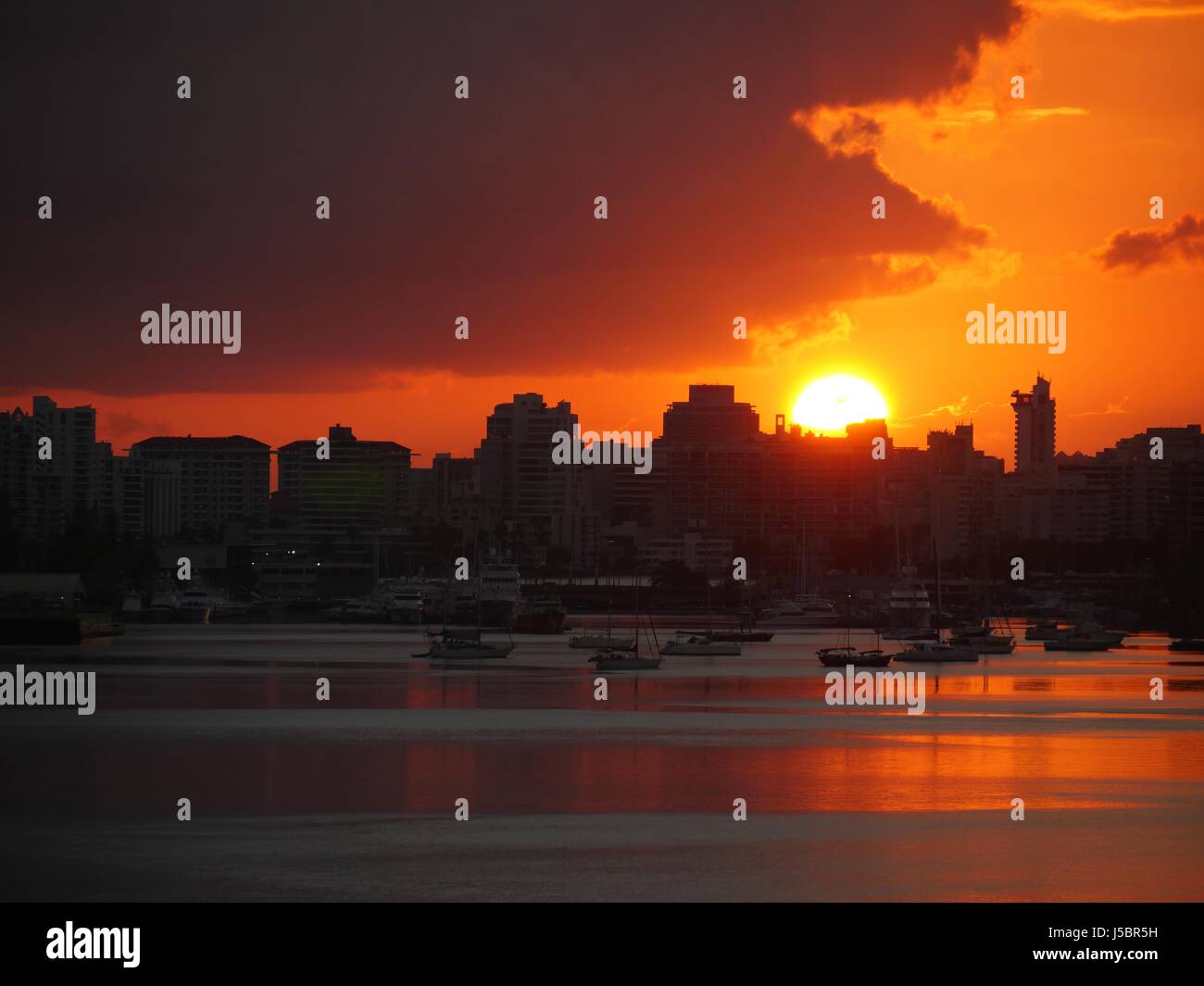 Sunset over Old San Juan waterfront A big sun sets over the port in the ...