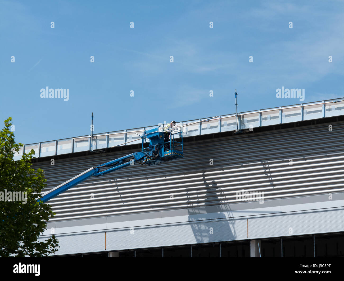 construction workers on mobile access platform installing on cladding