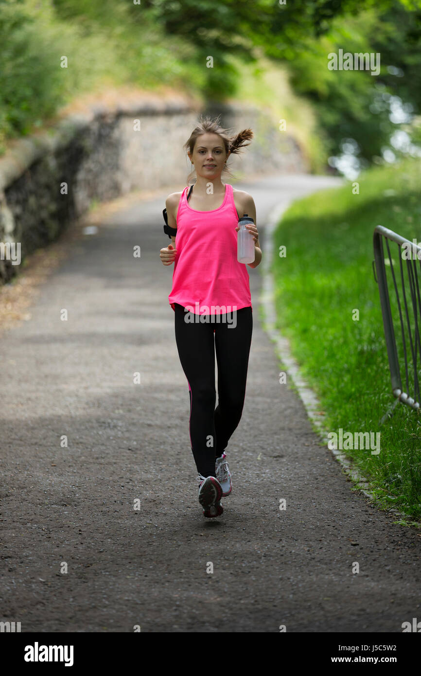 Athletic woman running outdoors. Action and healthy lifestyle concept. Stock Photo