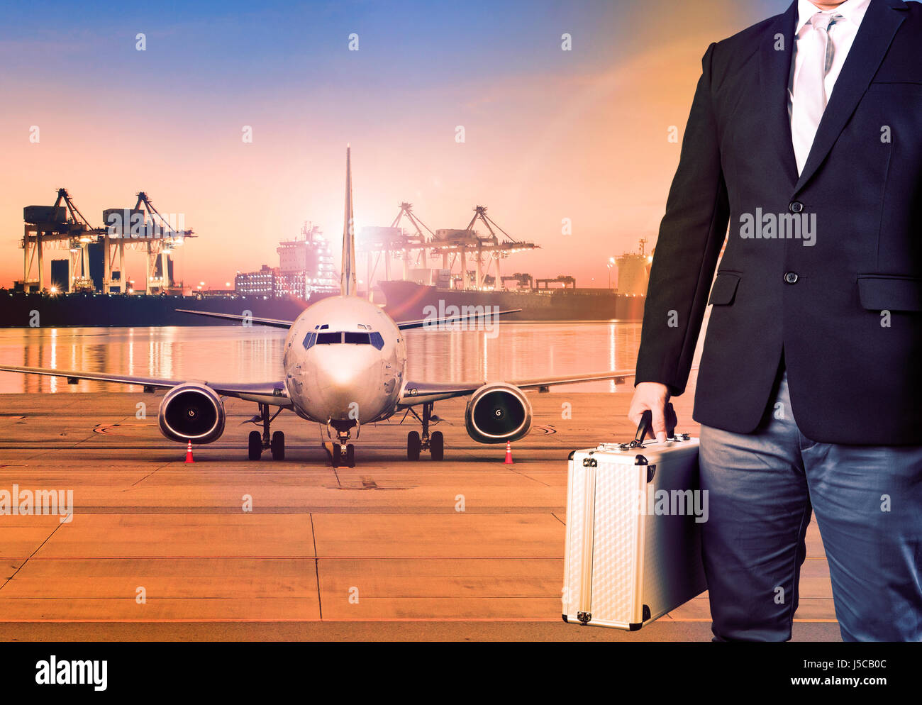 business man and breifcase standing against cargo plane in transportation background Stock Photo