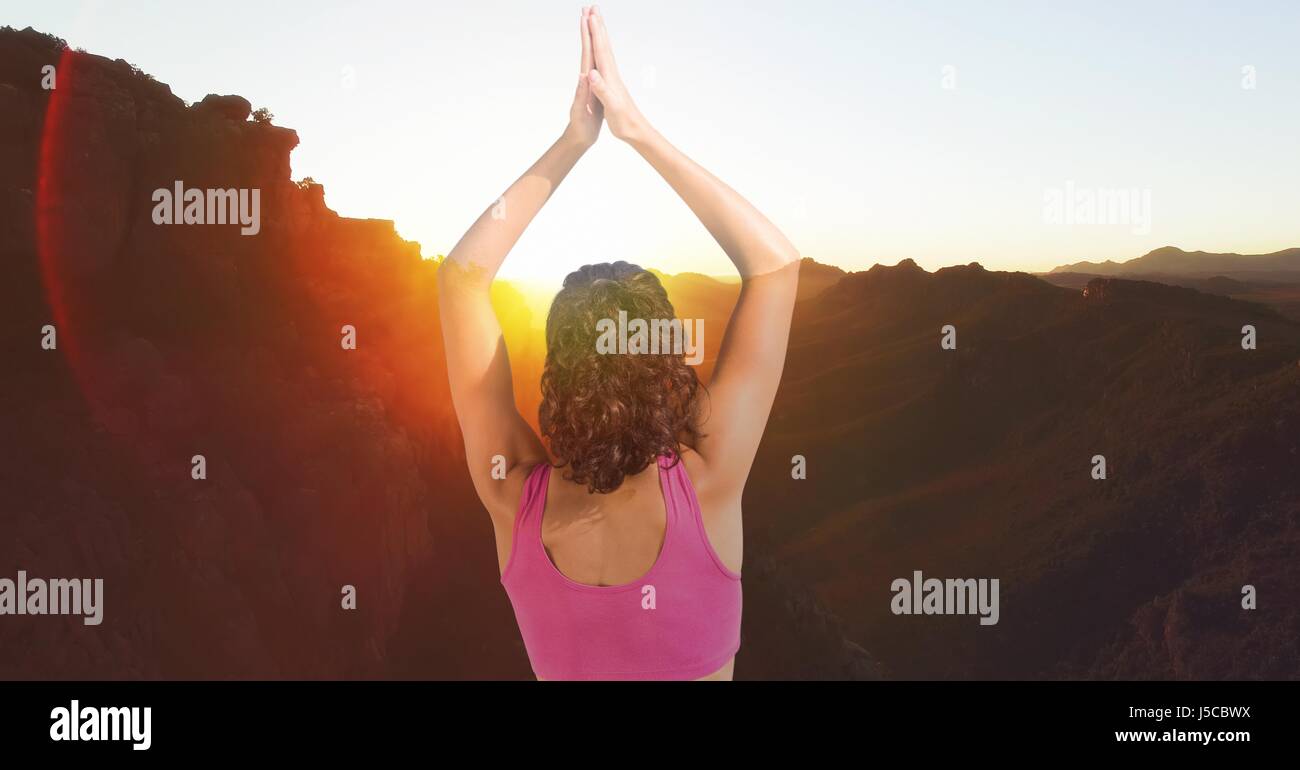Digital composite of Double exposure of woman with hands clasped performing yoga on mountains Stock Photo