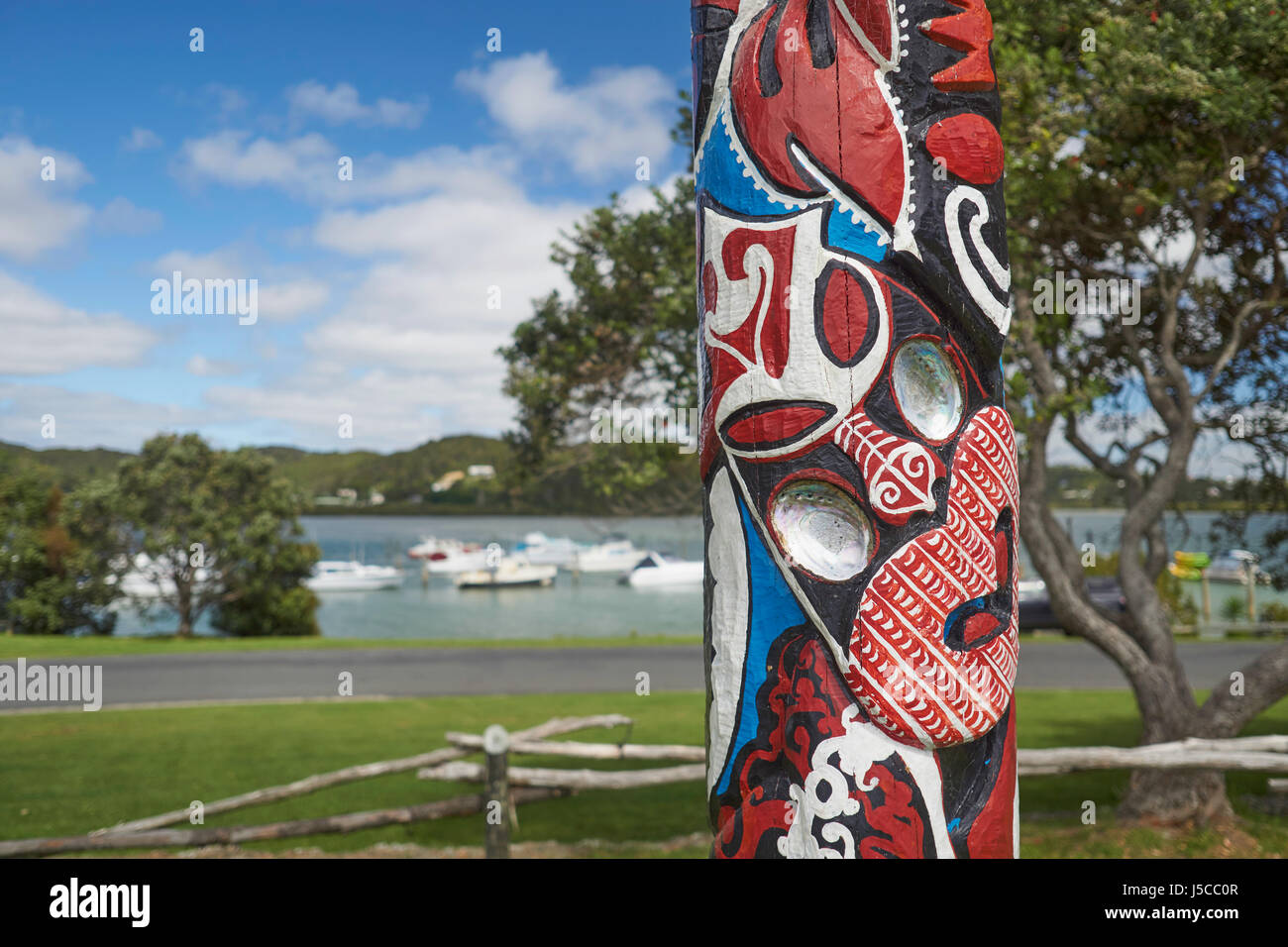 Colourful Maori carving (painted pou) in a park near Waitangi in Paihia, Bay of Islands, Northland, New Zealand Stock Photo