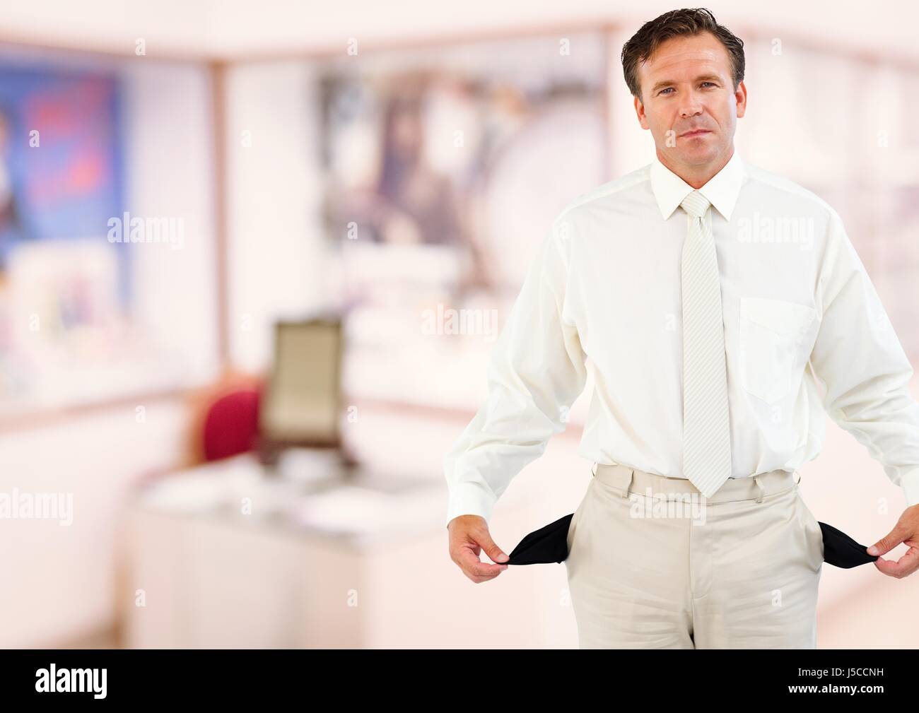Digital composite of Mature businessman showing empty pockets Stock Photo