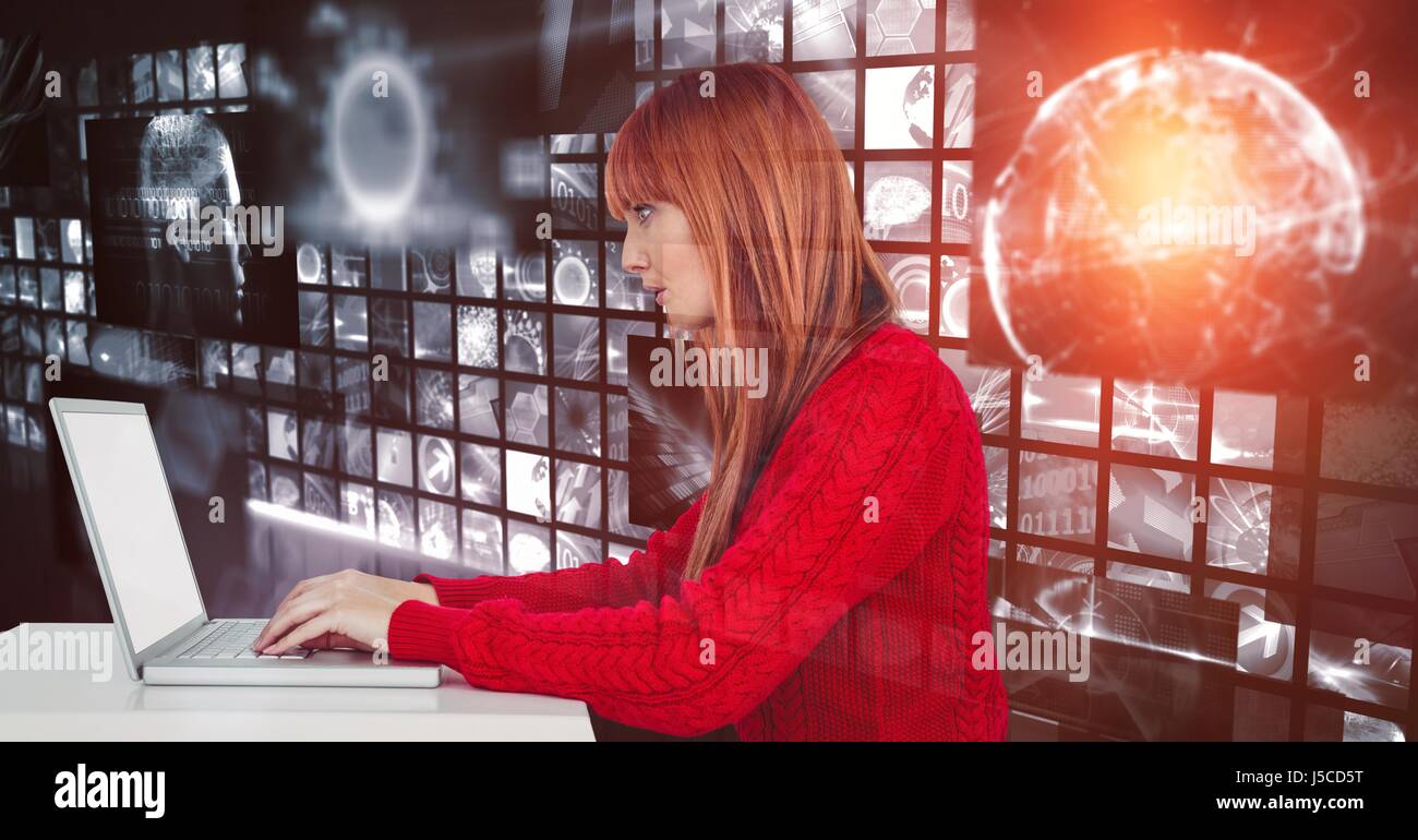 Digital composite of Female hacker using laptop against screens Stock Photo