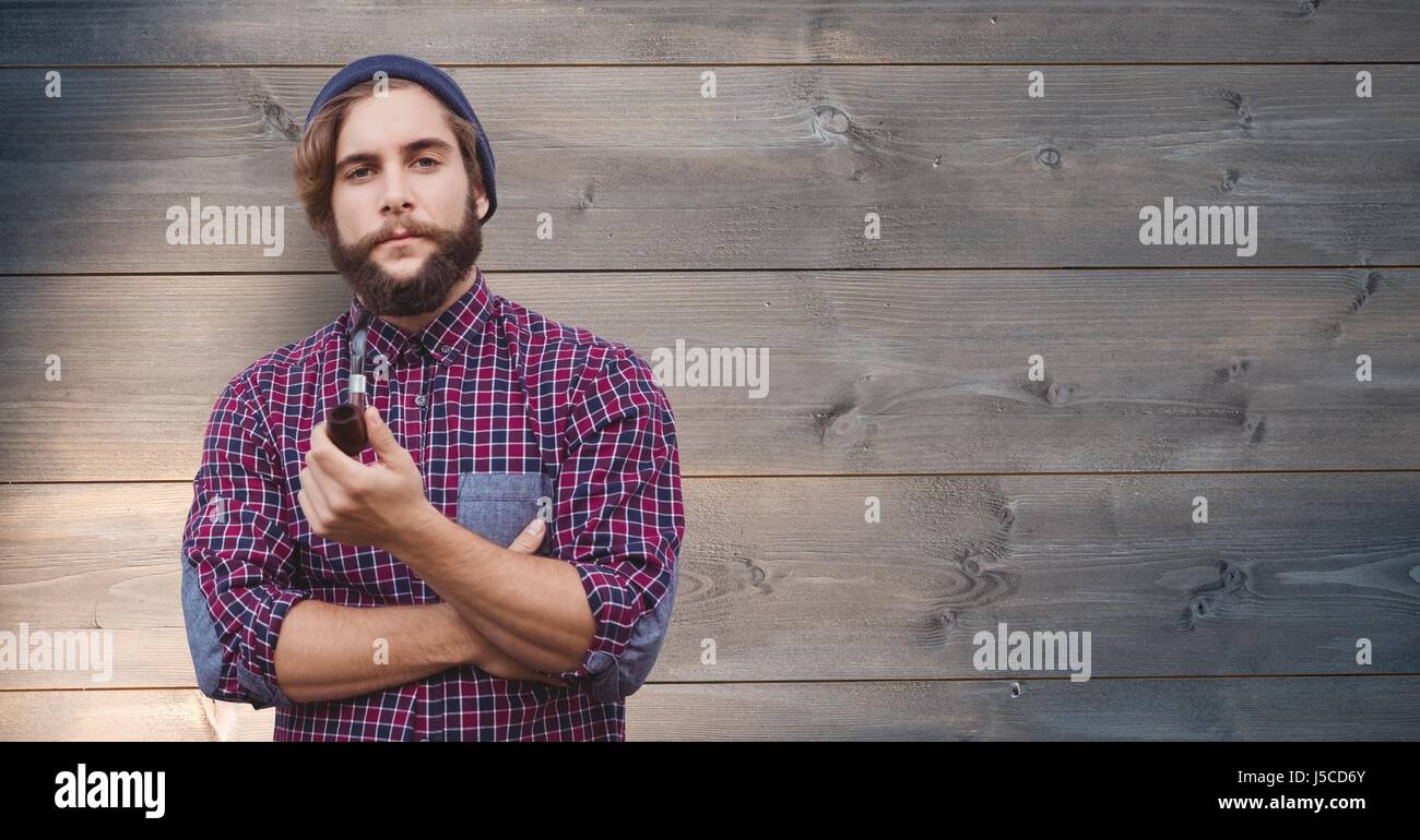 Digital composite of Portrait of man holding pipe against wooden background Stock Photo