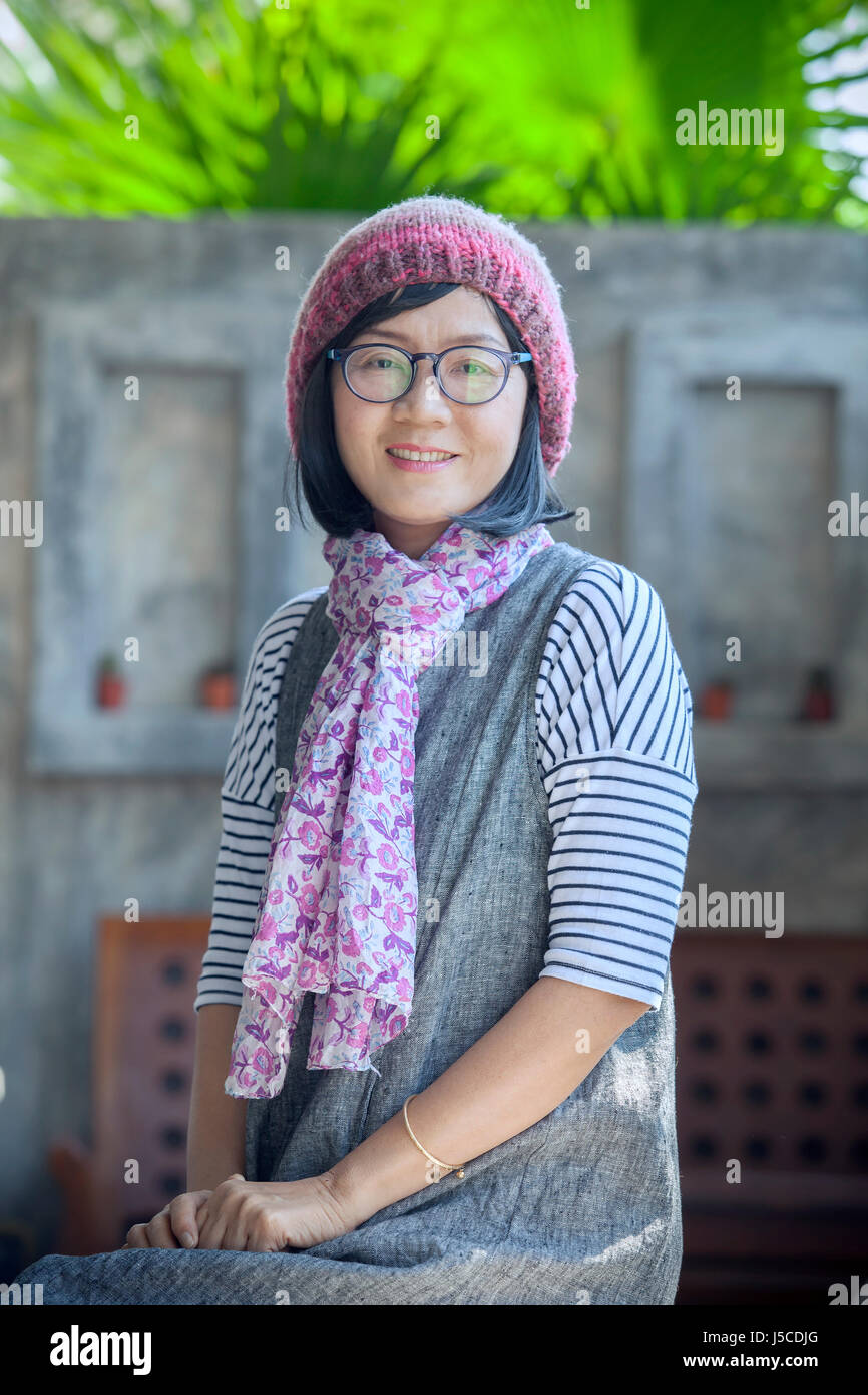 portrait of 40s years asian woman wearing wool hood and silk scarf toothy smiling with happiness emotion Stock Photo