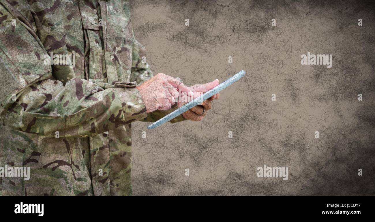 Digital composite of Soldier mid section with tablet and grunge overlay ...