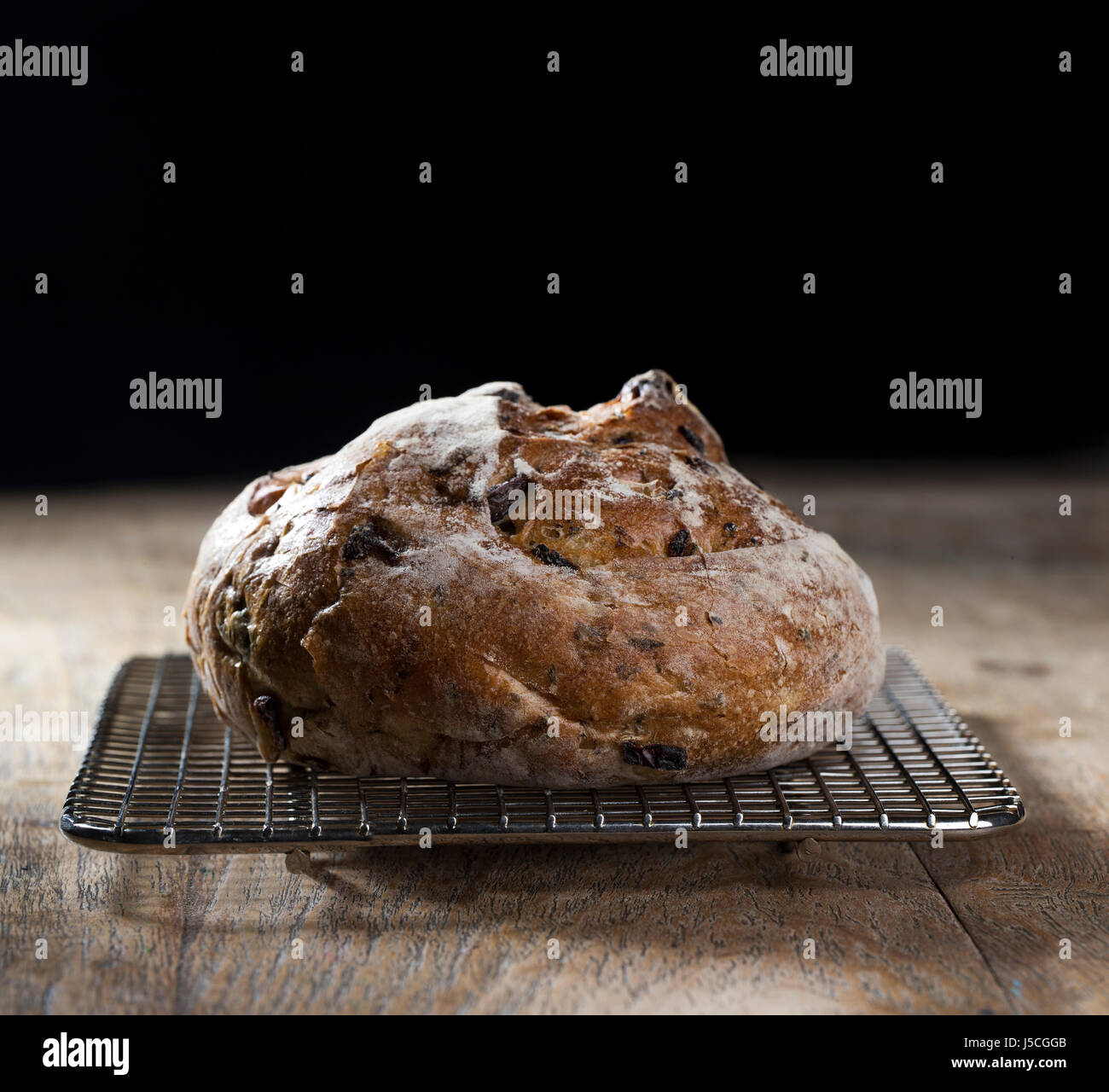 Side view of a rustic loaf of bread on an old wooden table Stock Photo ...