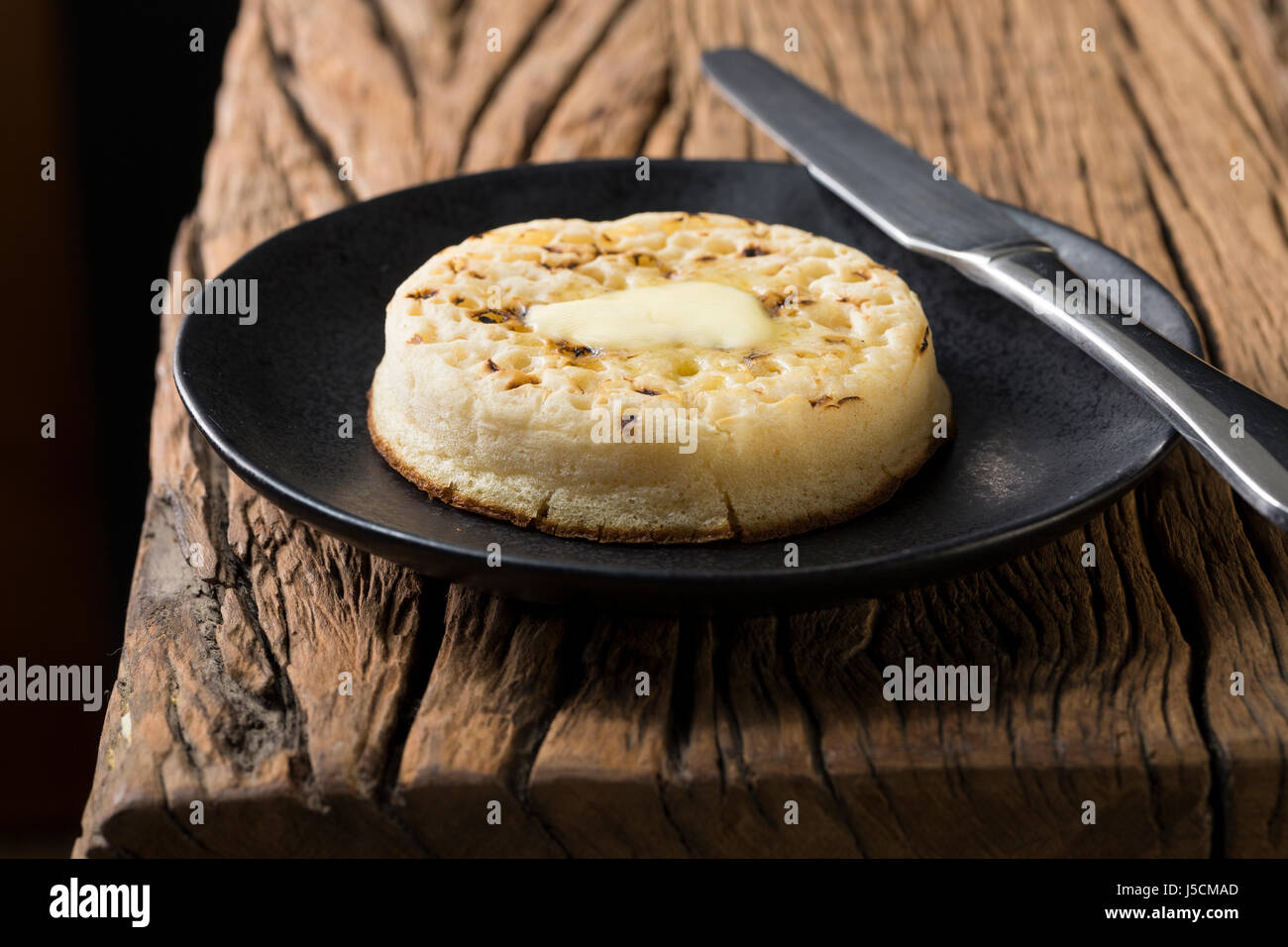 Toasted crumpets on a rustic wooden table. Stock Photo