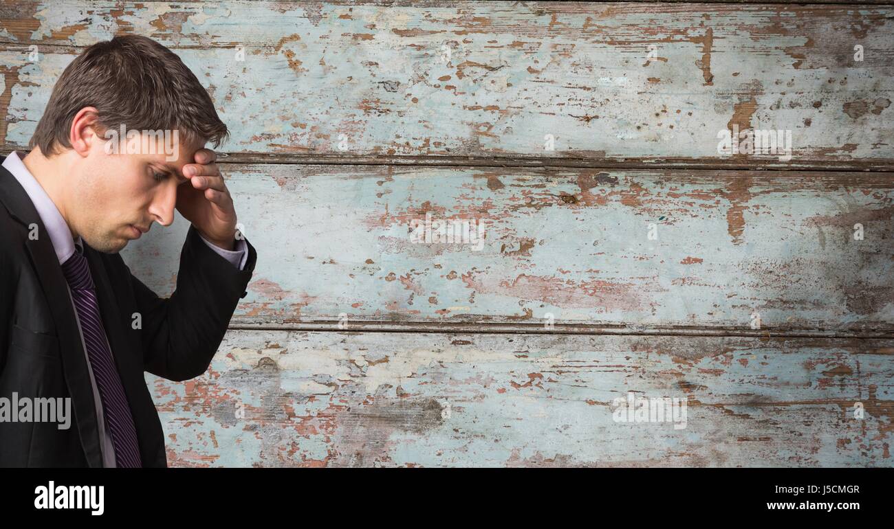Digital composite of Businessman suffering from headache over wooden wall Stock Photo