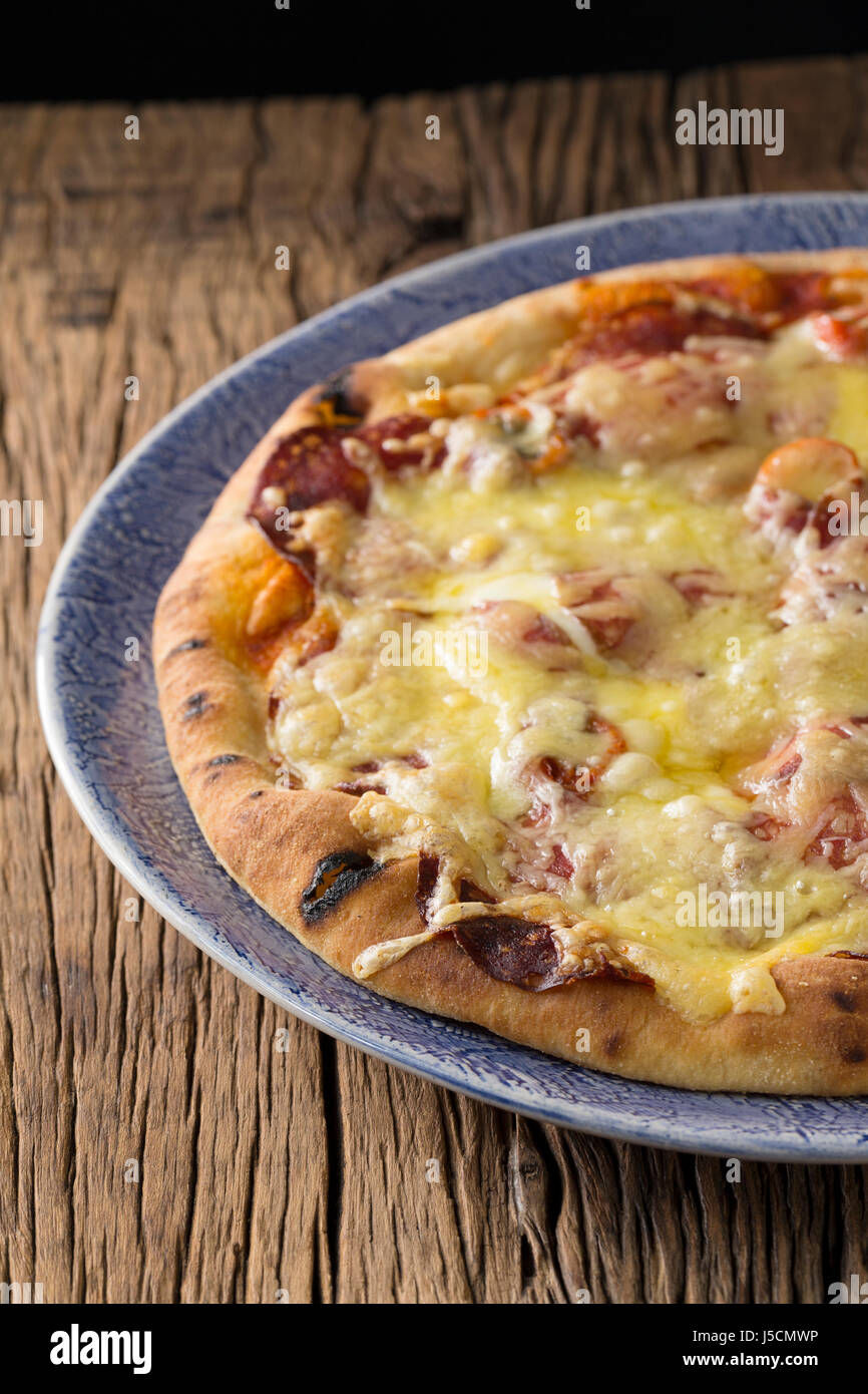 Fresh italian pizza served on a rustic wooden table. Stock Photo