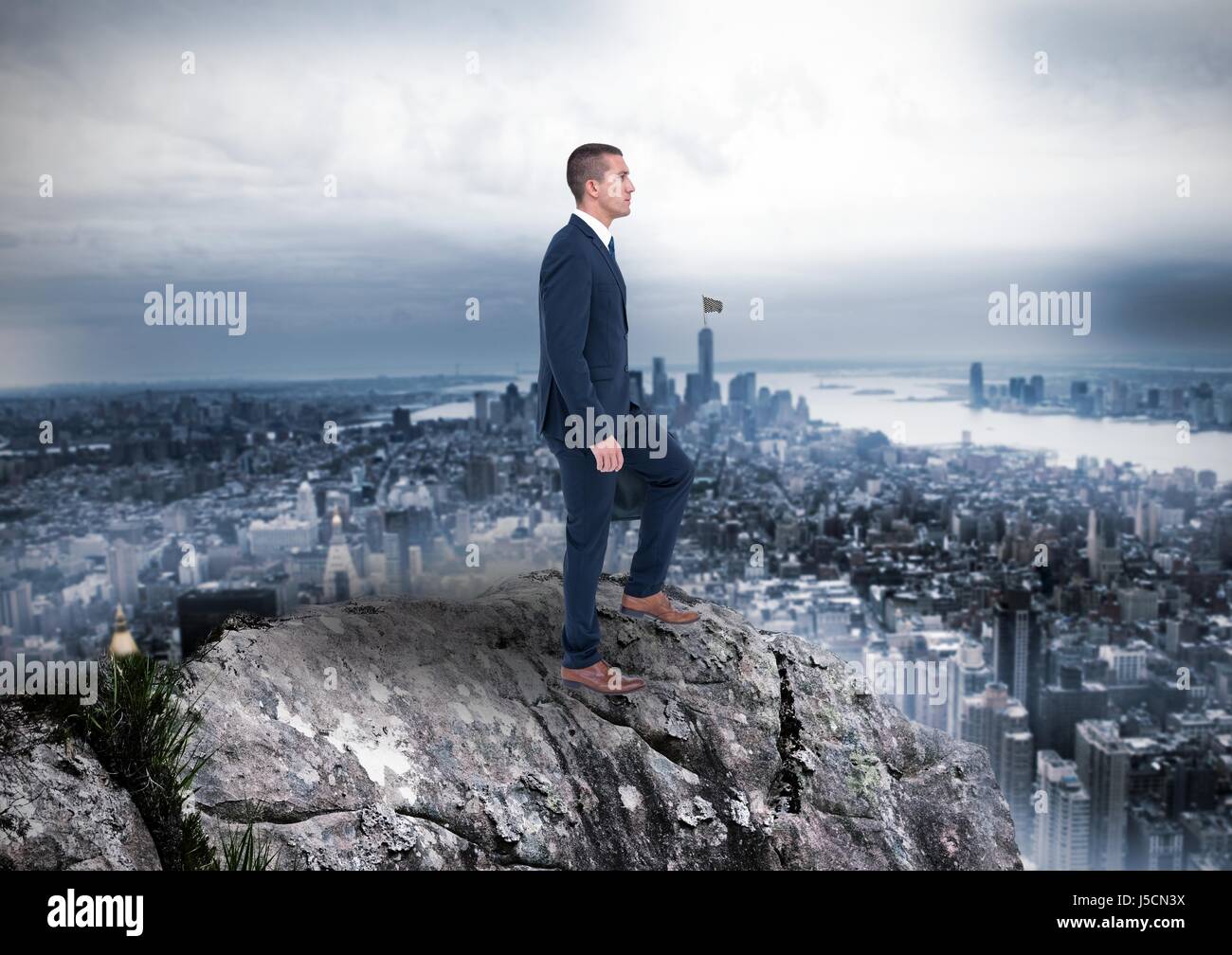 Digital composite of businessman in a rock with checker flag on a building of the city that is behind him Stock Photo