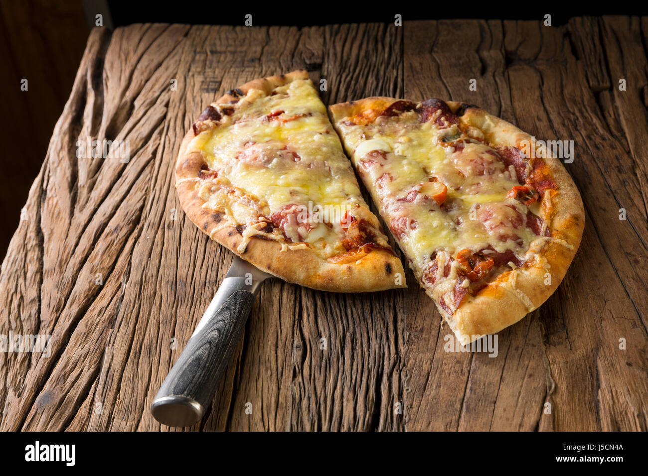 Fresh italian pizza served on a rustic wooden table. Stock Photo