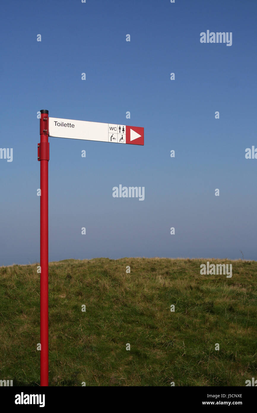 sign signal signposts direction pole toilet post hint meadow pointing pictogram Stock Photo
