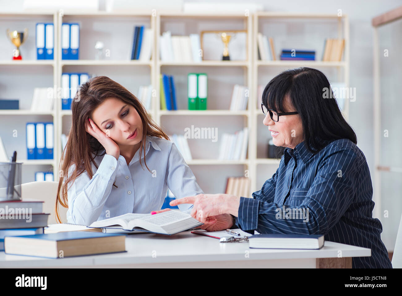 Young student and teacher during tutoring lesson Stock Photo - Alamy