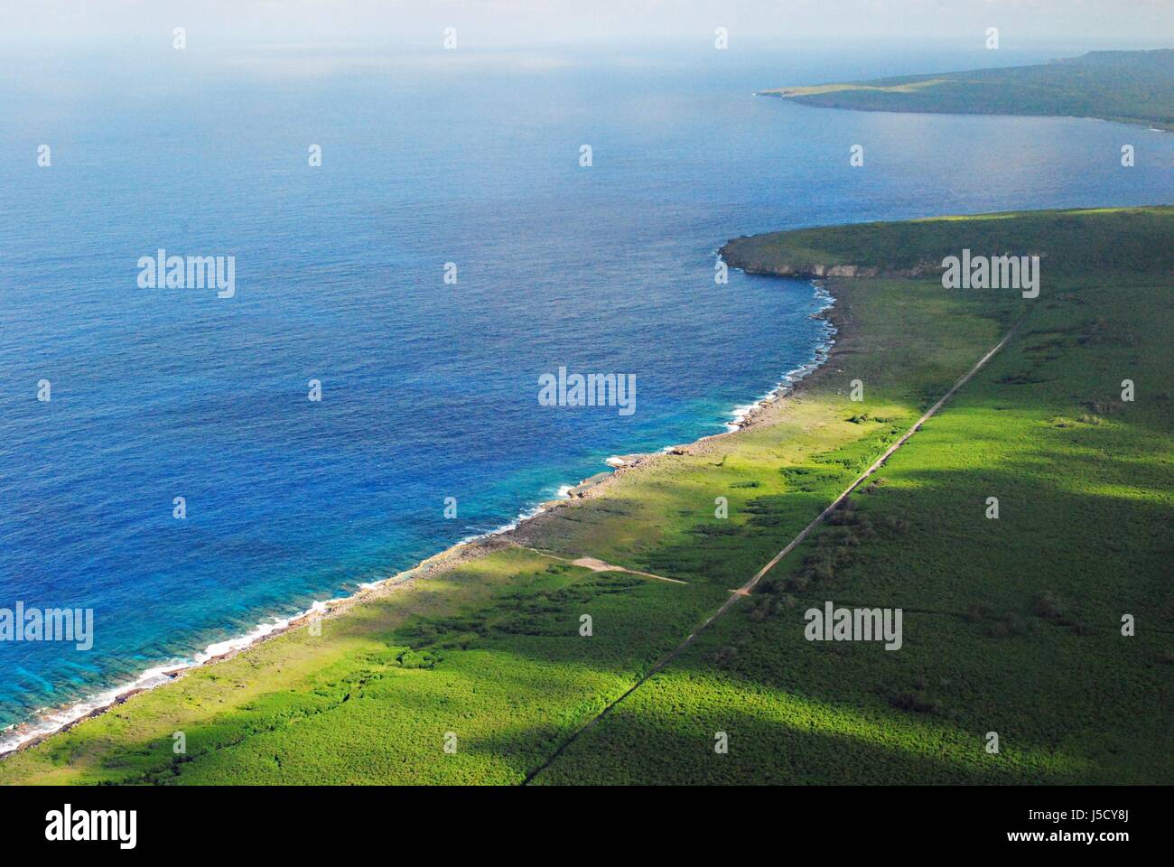 A beautiful aerial view of Tinian’s blue and green coastlines and cliff lines. Northern Mariana Islands Stock Photo