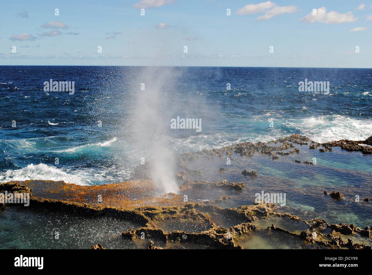 A small spray of water comes out of the blow hole in Tinian, Northern Mariana Islands Stock Photo
