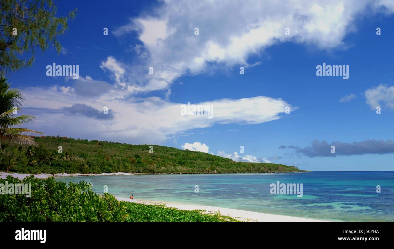 Beautiful blue skies and pristine waters welcome visitors to the Tachogna Beach on Tinian, Northern Mariana Islands. Stock Photo