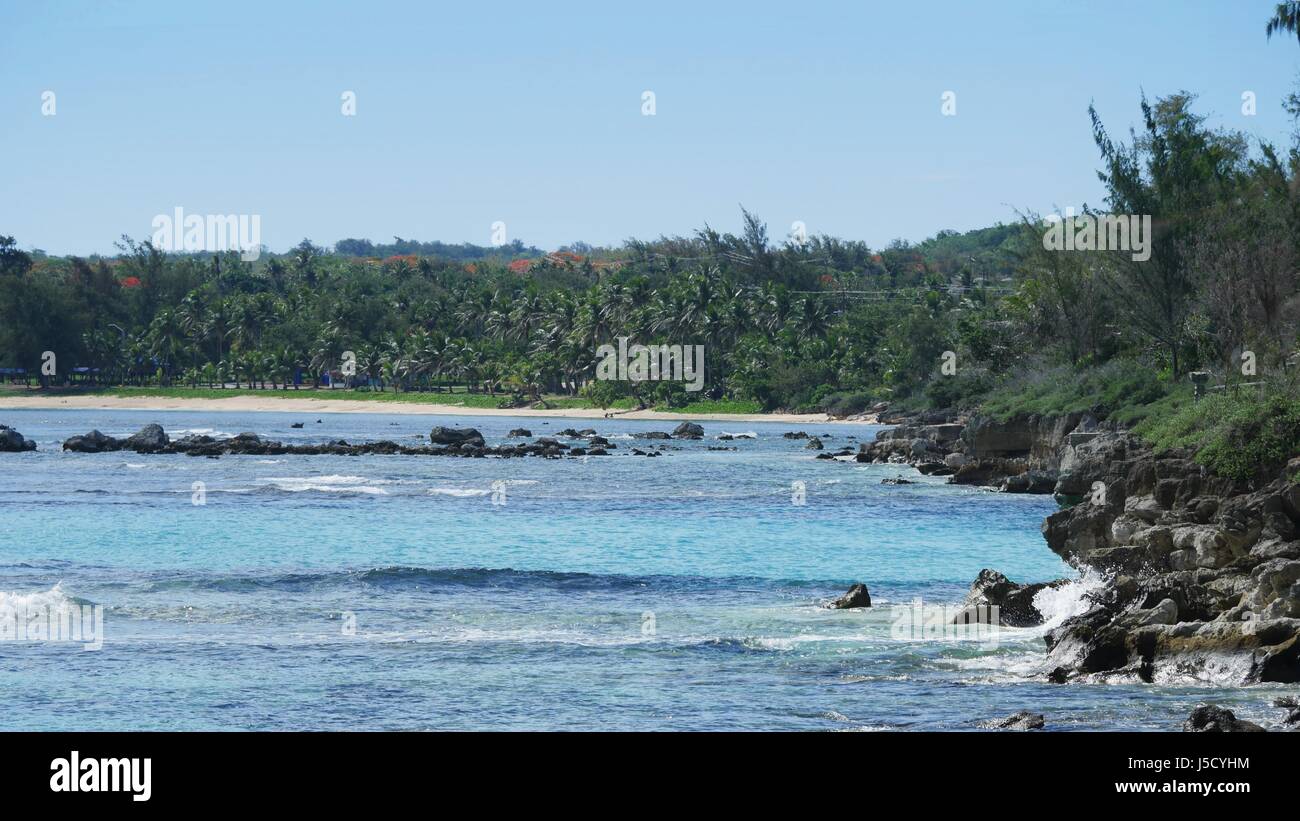 Tinian’s coastline is made up of soft white sand beaches and rocky cliffs. Stock Photo
