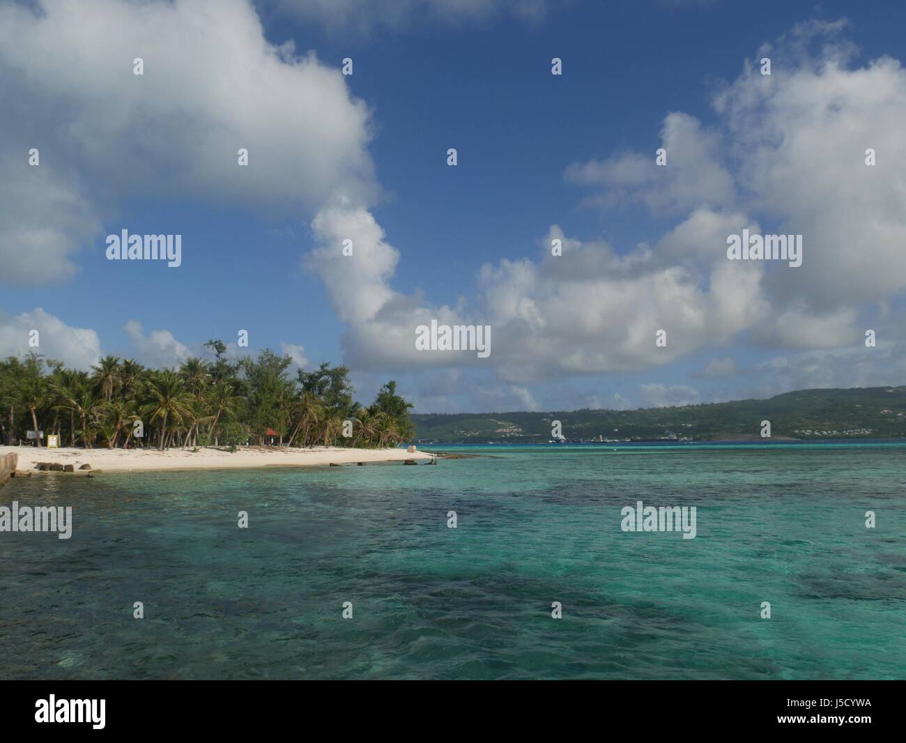 Crystal clear waters, white sandy beaches and beautiful clouds on a bright day in Managaha Island, Saipan Stock Photo