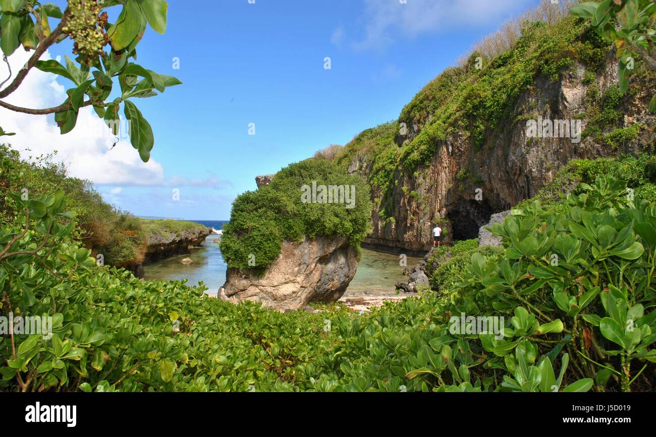 A hidden cove and water inlet that fills up during high tide in the North Field of Tinian, Northern Mariana Islands. Stock Photo