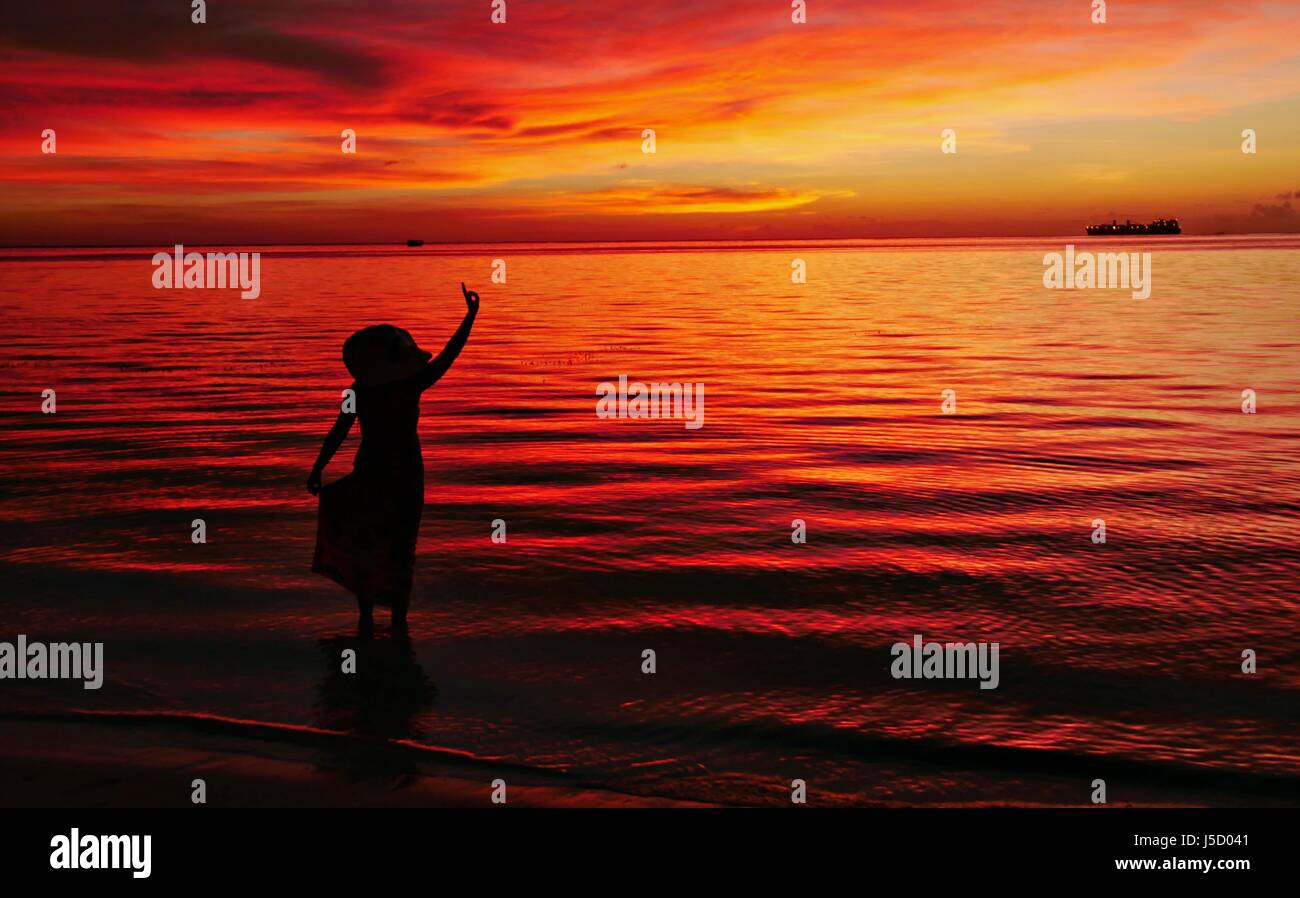 A woman’s silhouette poses with a stunning sunset backdrop Stock Photo ...