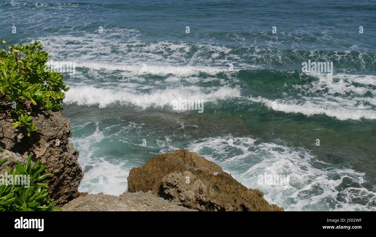 Waves rolling into rocky cliffs White foaming waves roll and slap in