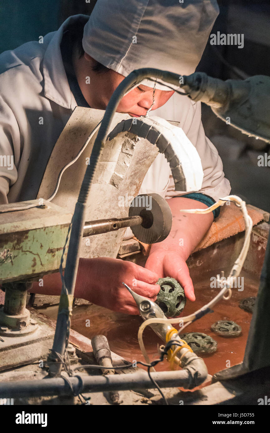 BEIJING, CHINA-26th MARCH 2014:- The carvers are cutting jade into intricate patterns for tourists. Stock Photo