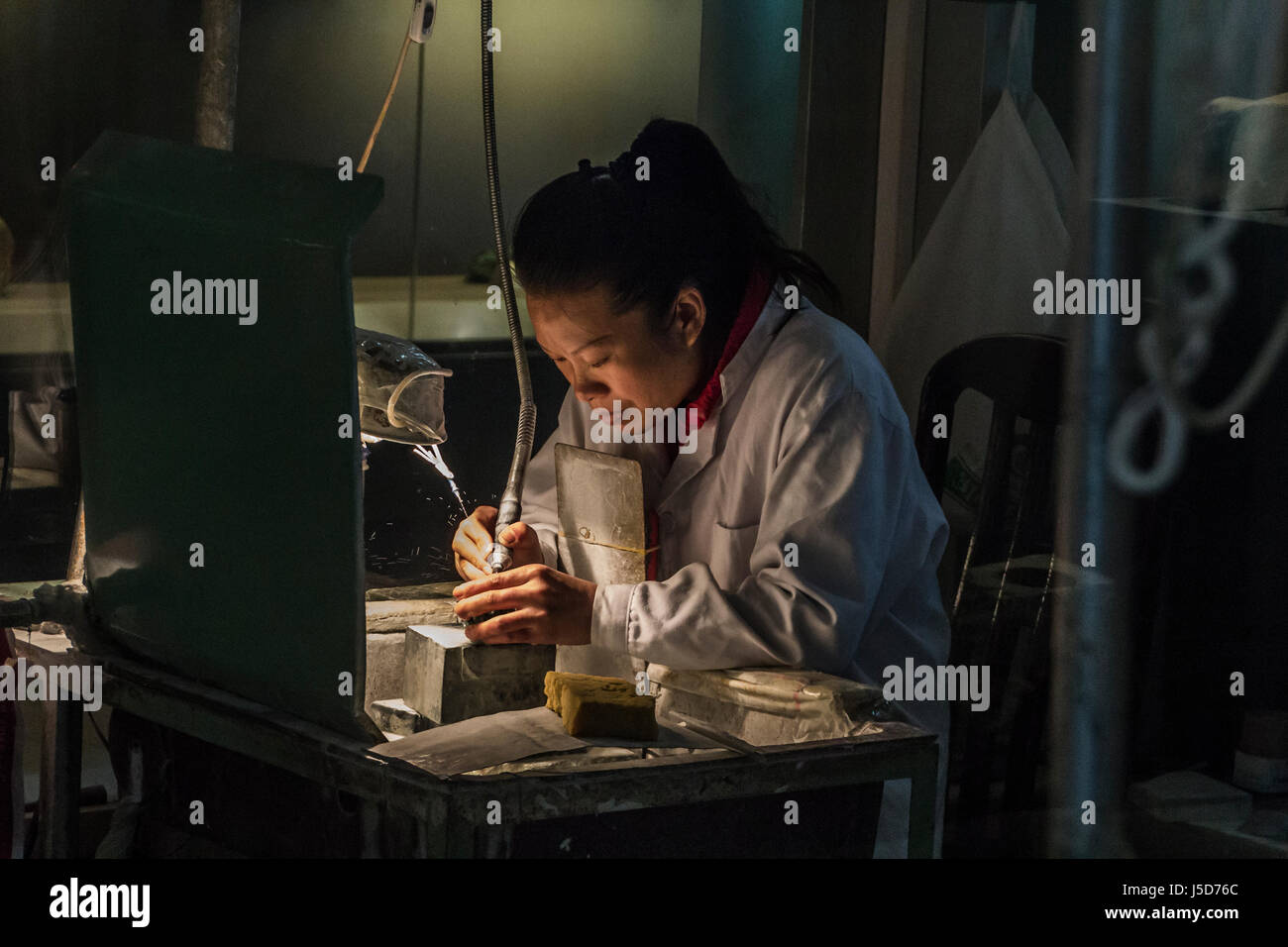 BEIJING, CHINA-26th MARCH 2014:- The carvers are cutting jade into intricate patterns for tourists. Stock Photo